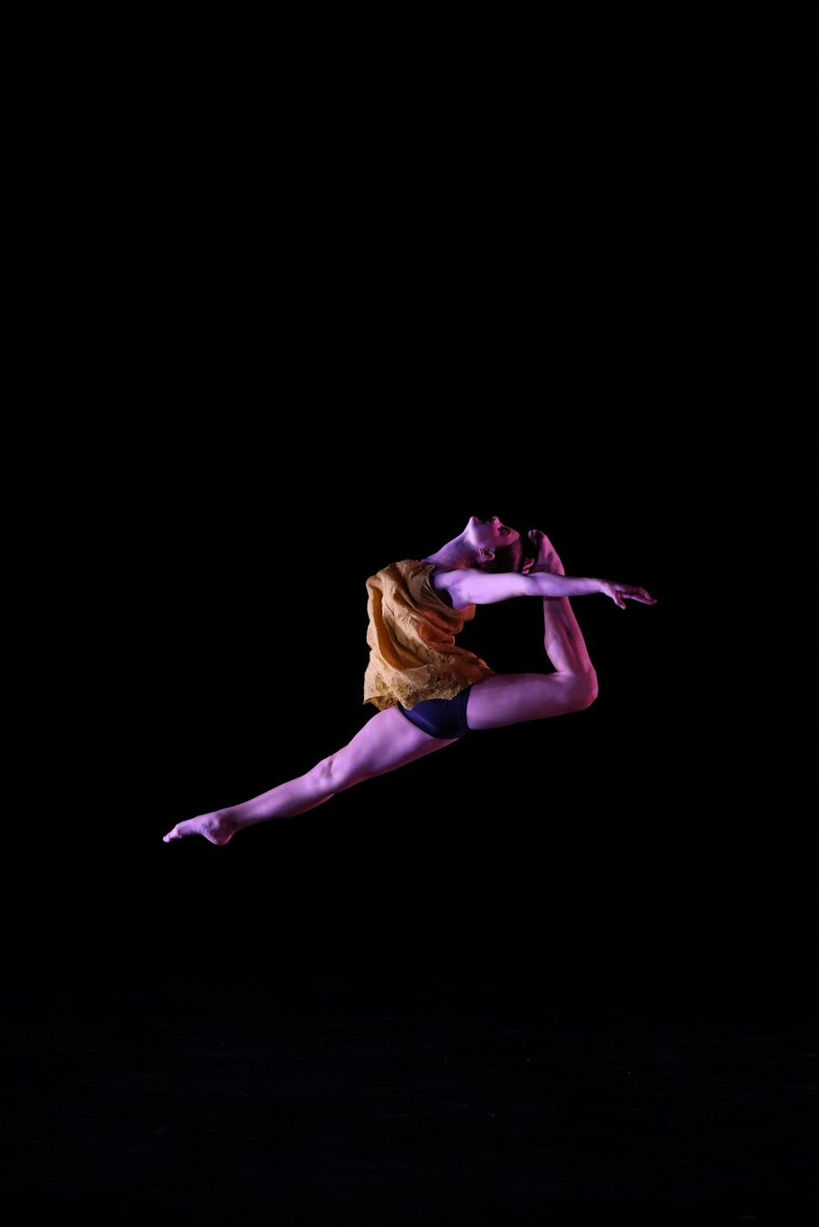A dancer in violet light with arms extended overhead, lower body hidden by the overlay
